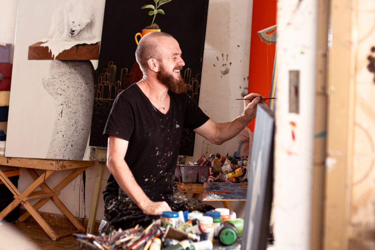 Ivaan Hansen pintando uma tela em seu ateliê